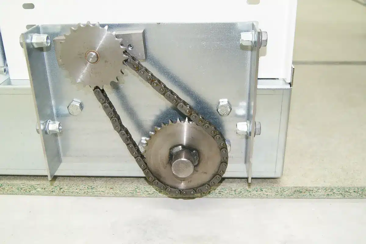 Détail de rayonnage mobile, démultiplication à chaîne sur une base mobile pour une entreprise de BTP en région Rhône-Alpes