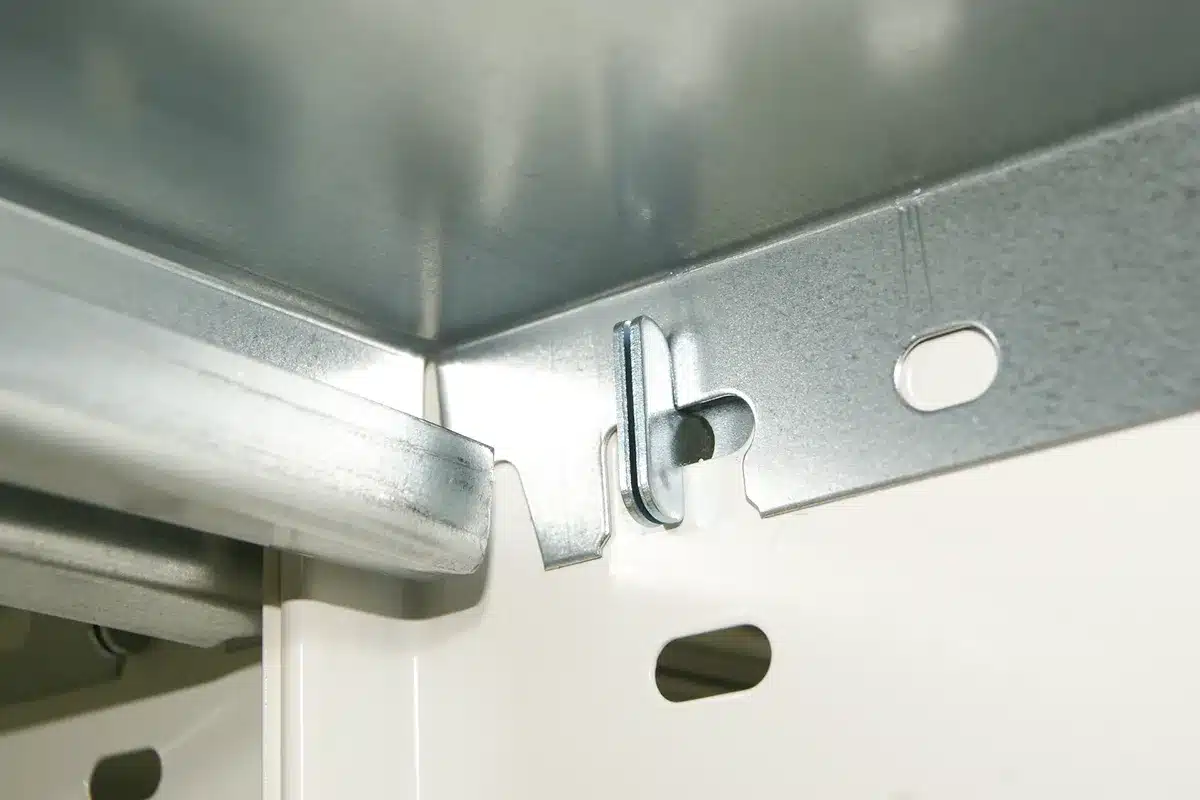 Détail de rayonnage archives, liaison d’une tablette à la paroi par cavalier, modifiable sans outil pour une entreprise de BTP