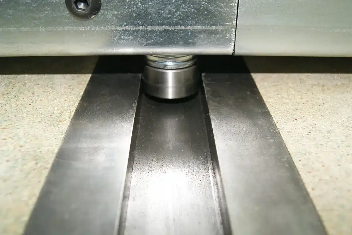 Détail de rayonnage mobile, galet de centrage et rail de guidage sur châssis mobile pour une entreprise de travaux